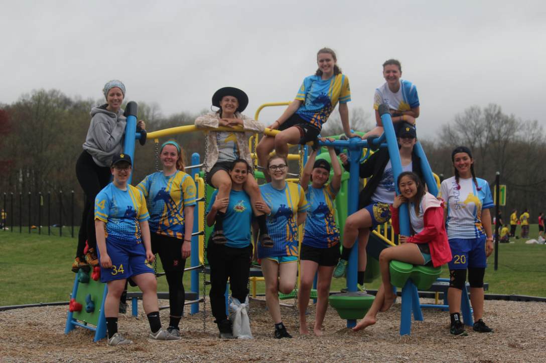 Ultimate team posing for photo on a jungle gym. The team's jerseys are blue and yellow.